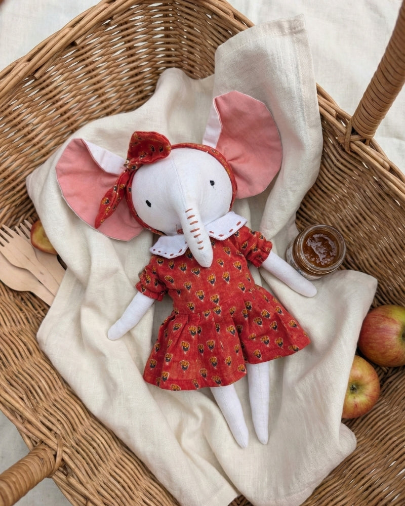 White premium cotton stuffed elephant toy in a red dress with large floppy pink ears and hand-stitched eyes 